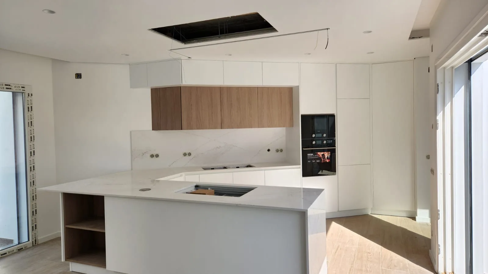Cozinha aberta com ilha e bancada branca