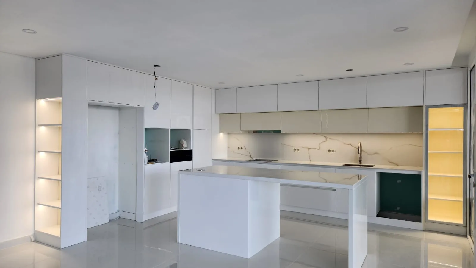 Cozinha branca com ilha e vitrines iluminadas